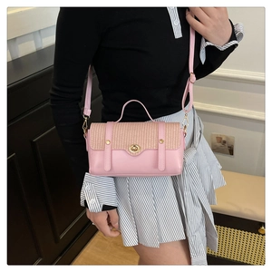 Detail of pink leather handbag with woven flap and gold metal twist lock closure