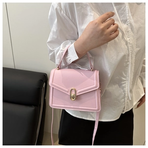 Pink square shoulder bag featuring gold oval twist lock and slim matching handle detail
