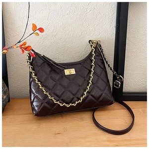 Dettaglio borsa tote in pelle trapuntata marrone scuro con catena dorata e chiusura a scatto