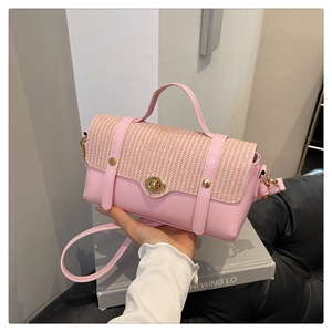 Close-up of pink faux leather and beige woven fabric textures on handbag with gold lock