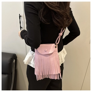 Détail d'un sac bandoulière rose à franges avec design à glands porté par un mannequin