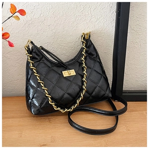 Dettaglio borsa tote in pelle nera trapuntata con chiusura a scatto dorata e catenella