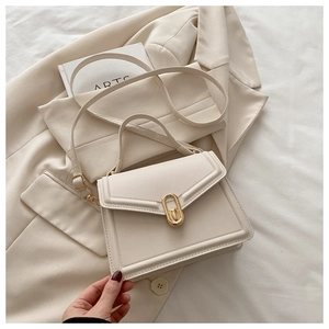 Détail d'un sac à main crème en cuir avec fermoir doré et bandoulière réglable