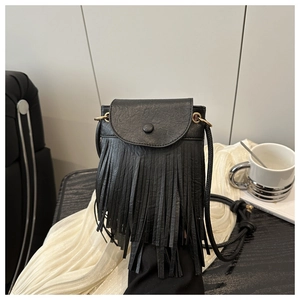 Détail d'un petit sac bandoulière en cuir noir à texture grainée avec de longues franges