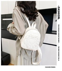 Detail view of white lace heart backpack showing delicate embroidery and texture