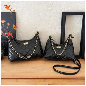 Borse tote in pelle nera trapuntata in due misure con catena dorata su base di legno