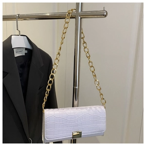 Detail of white crocodile pattern bag with gold metal chain and square lock closure
