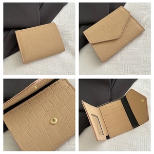 Dettagli del portafoglio beige con trama coccodrillo e chiusura a scatto magnetico dorata