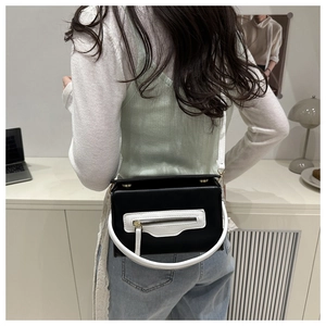 Dettaglio borsa a mano bicolore con manico a U bianco e trama in pelle nera elegante
