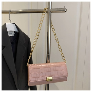 Detailed view of pink croc-embossed leather with gold metal chain and rectangular lock