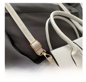 Detail of adjustable white leather strap with golden rectangular buckle and lobster clasp