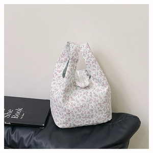 Detailed macro view of floral canvas tote bag showing white ruffle trim and striped lining