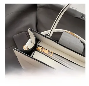 Macro detail of smooth golden zipper and premium interior lining on black white handbag