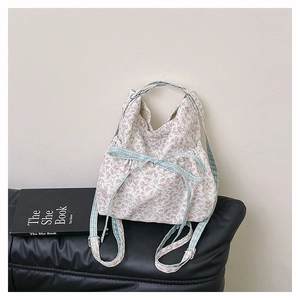 Detail of floral canvas bag with pink flower prints and blue checkered bow decoration