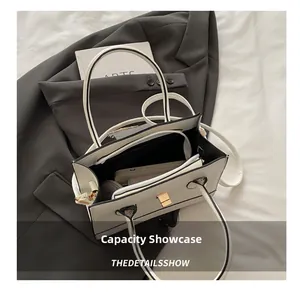 Interior view showing the large capacity of this elegant black and white lock handbag