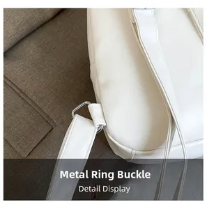 Macro detail of silver-tone metal D-ring hardware on a white leather shoulder bag