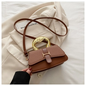 Detail of a brown leather handbag with gold H buckle and irregular metal handle
