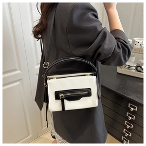 Dettaglio di una borsa a tracolla chic bicolore bianco e nero con finiture dorate