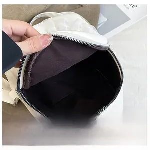Internal view of a white leather handbag showing large capacity and zipper closure