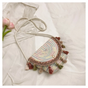 Détail du sac en paille bohème avec coutures en zigzag et bordures à franges colorées
