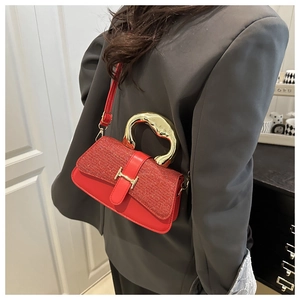 Detailed side view of a red leather bag with sequin texture and gold H-clasp