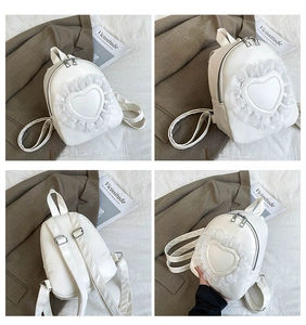 Detail of white PU leather mini backpack with heart lace edge and dual zip compartments
