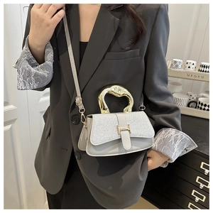 Detail of light grey crossbody bag featuring a golden H buckle and textured tweed flap