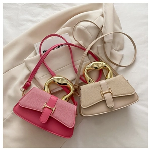 Detail of fuchsia and beige textured handbags with unique gold-tone metal handles