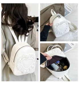 Detail view of white backpack with heart lace ruffles showing interior capacity and fit