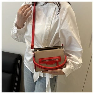 Borsa a tracolla beige e rossa a contrasto indossata da una modella con camicia bianca