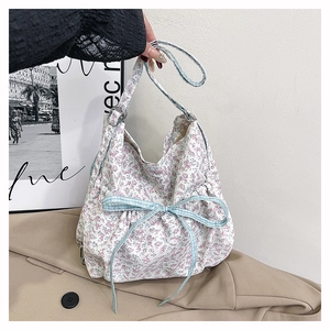 Floral canvas shoulder bag detail featuring a light blue checkered bow and pink blossom print