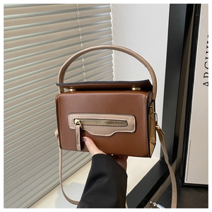 Dettaglio borsa a tracolla marrone patchwork con tasca a zip e trama in pelle sintetica PU