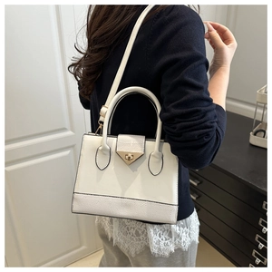 Chic white crossbody bag with metal buckle and texture detail worn by a model