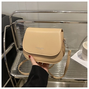 Detail of beige saddle bag with Fashion Trend embossing and sleek silver metal buckle