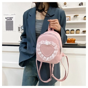Pink heart lace mini backpack for women held by hand in a lifestyle shop setting