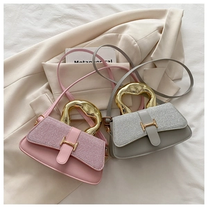 Close-up of small crossbody bags with sequin texture and gold H-shaped buckles