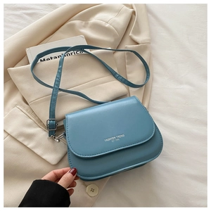 Detailed close-up of light blue saddle crossbody bag with Fashion Trend printed text
