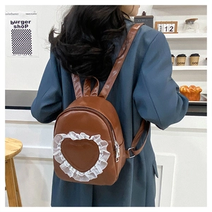 Detail view of brown PU leather mini backpack with white lace heart on the back