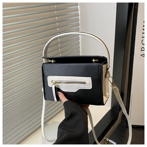 Dettaglio della borsa in pelle a contrasto bianco e nero con zip e finiture dorate
