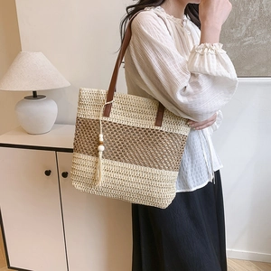 Fashion woven straw tote bag with brown contrast stripes and bohemian tassel accents