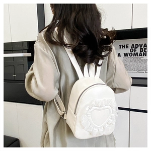 Detail of white mini backpack with bunny ears and lace heart embroidery on back
