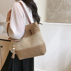 Women's woven tote bag in straw with brown leather straps and bohemian wood bead tassel