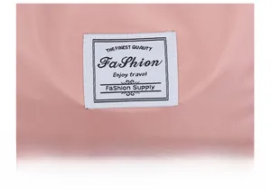 Close-up of a pink polyester fabric detail with a white embroidered Fashion logo label