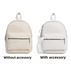 Comparison of mini straw backpacks in beige and white with lace pearl charm detail