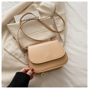 Detailed close-up of beige square shoulder bag with Fashion Trend logo and leather texture