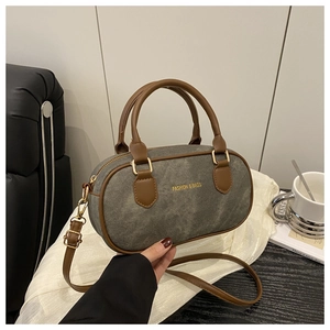 Close-up of vintage Boston bag with grey canvas, brown leather trim and golden hardware