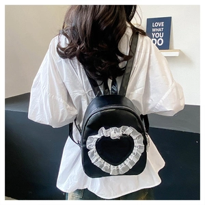 Close-up of black backpack with heart-shaped cutout and white lace trim detail