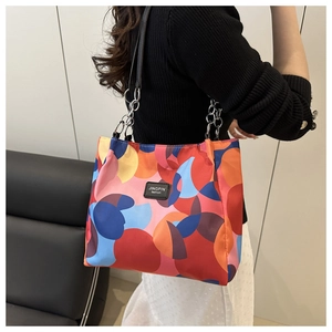 Detail of colorful abstract pattern on a large nylon tote bag with metal chain