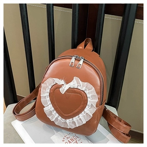 Detailed close-up of brown PU leather mini backpack with lace heart and silver zipper