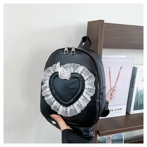 Detail of a black PU leather heart backpack with white lace trim and silver zippers